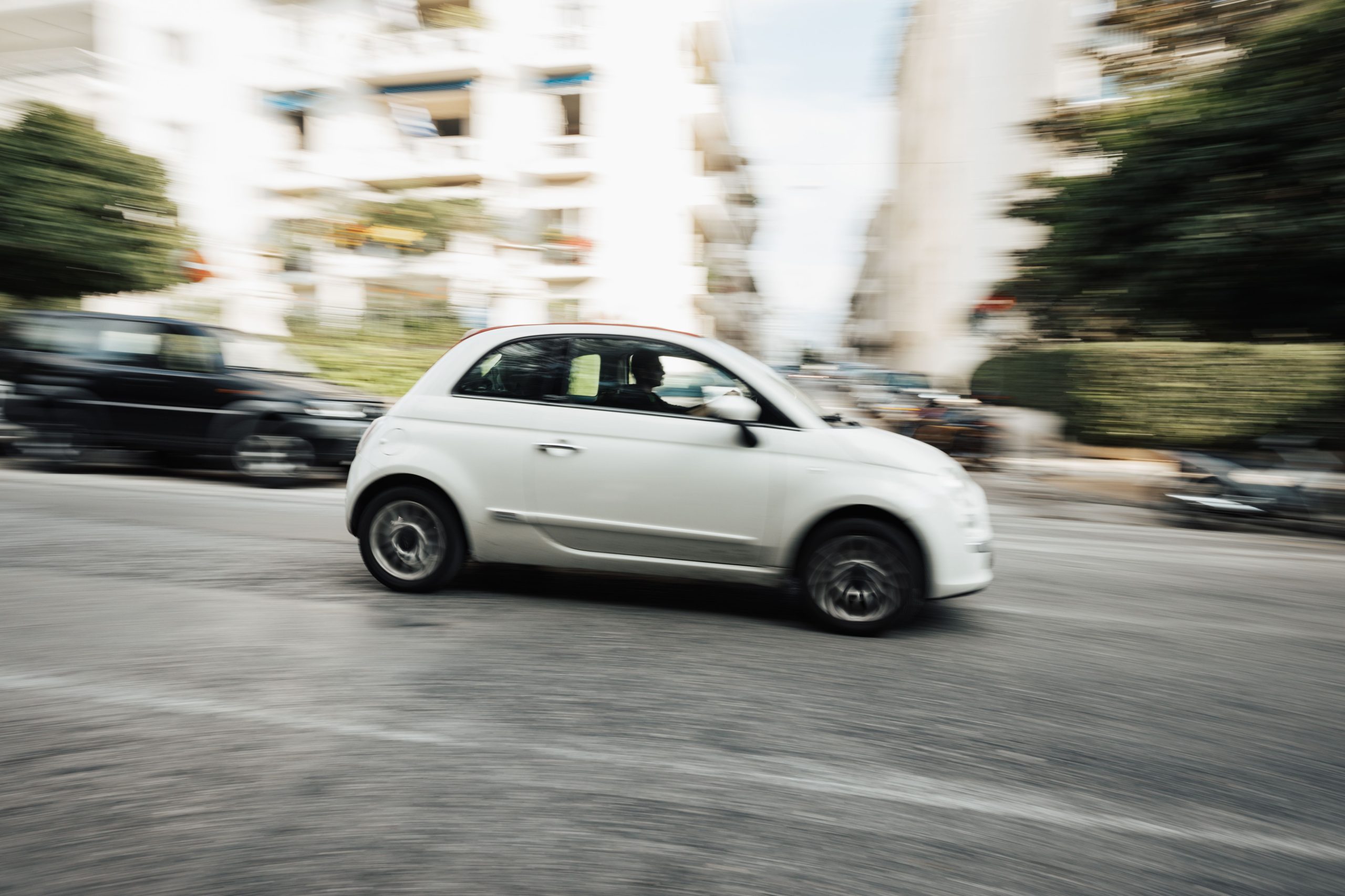 Clio compacte blanche circulant vite en milieu urbain