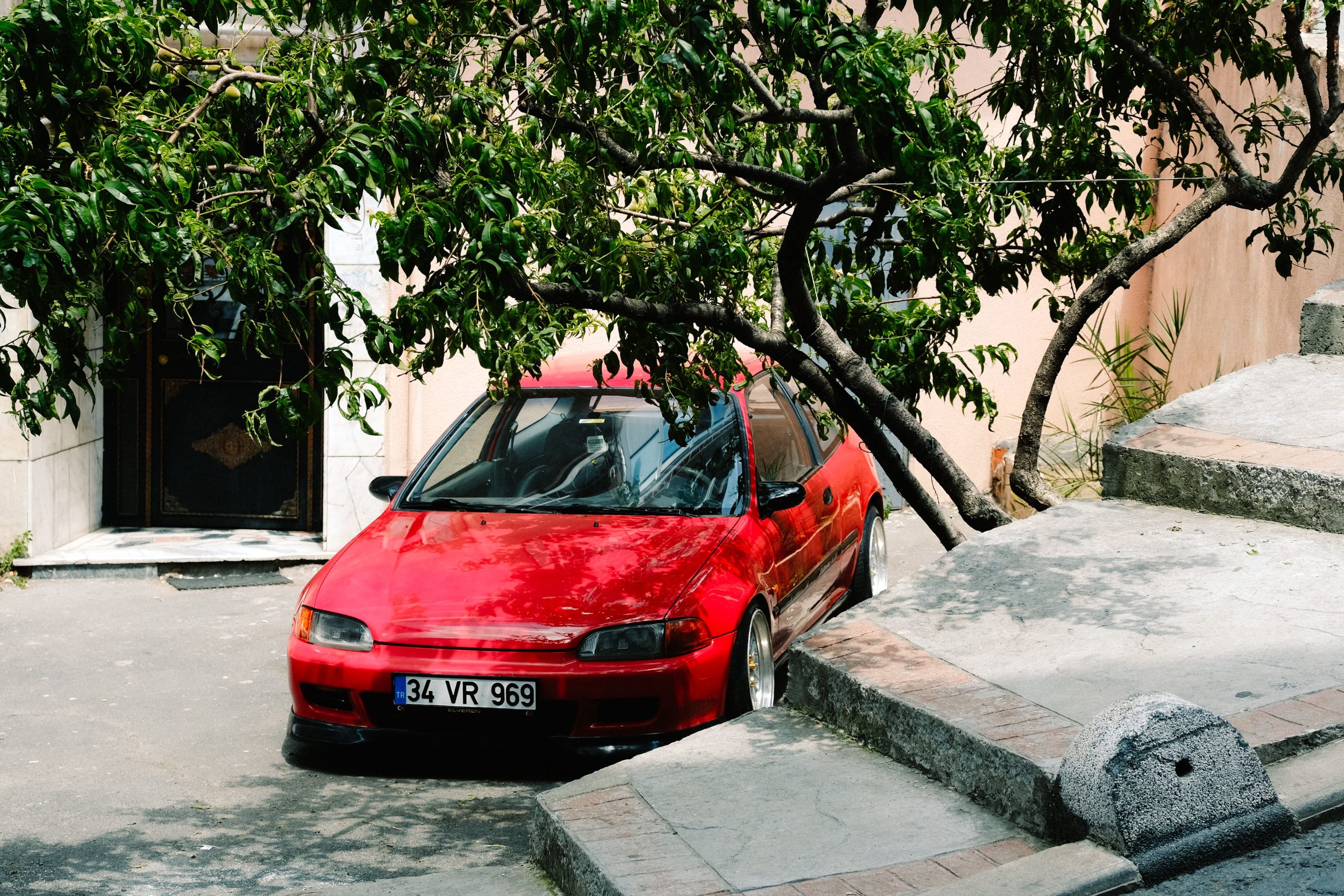 Twingo 2 rouge garée sous un arbre