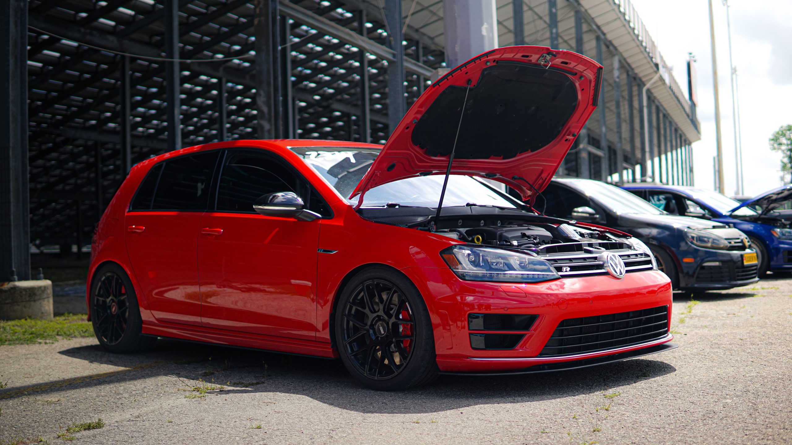 Volkswagen Golf rouge vif capot ouvert parking
