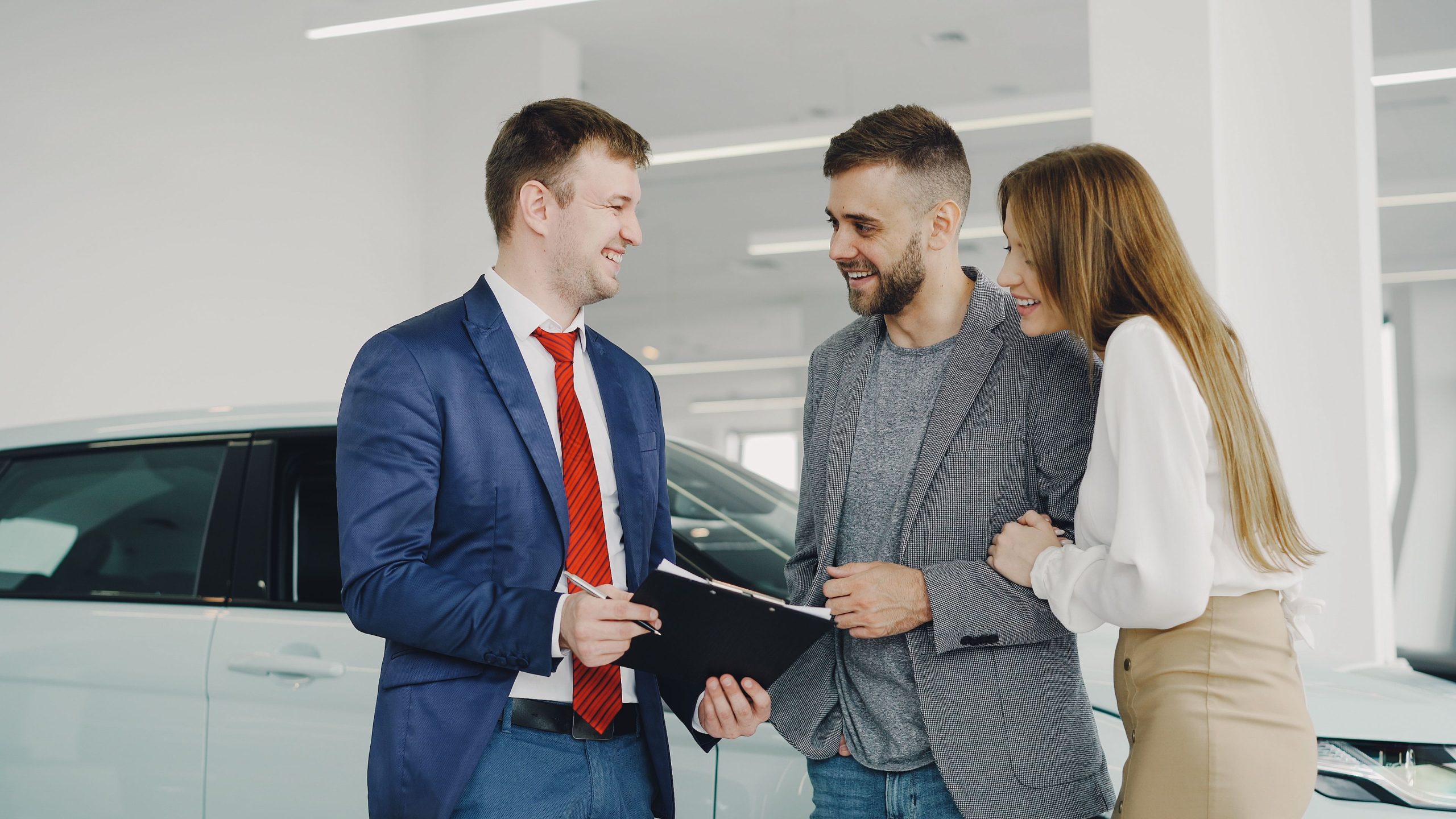 Couple achete nouvelle Audi avec vendeur souriant