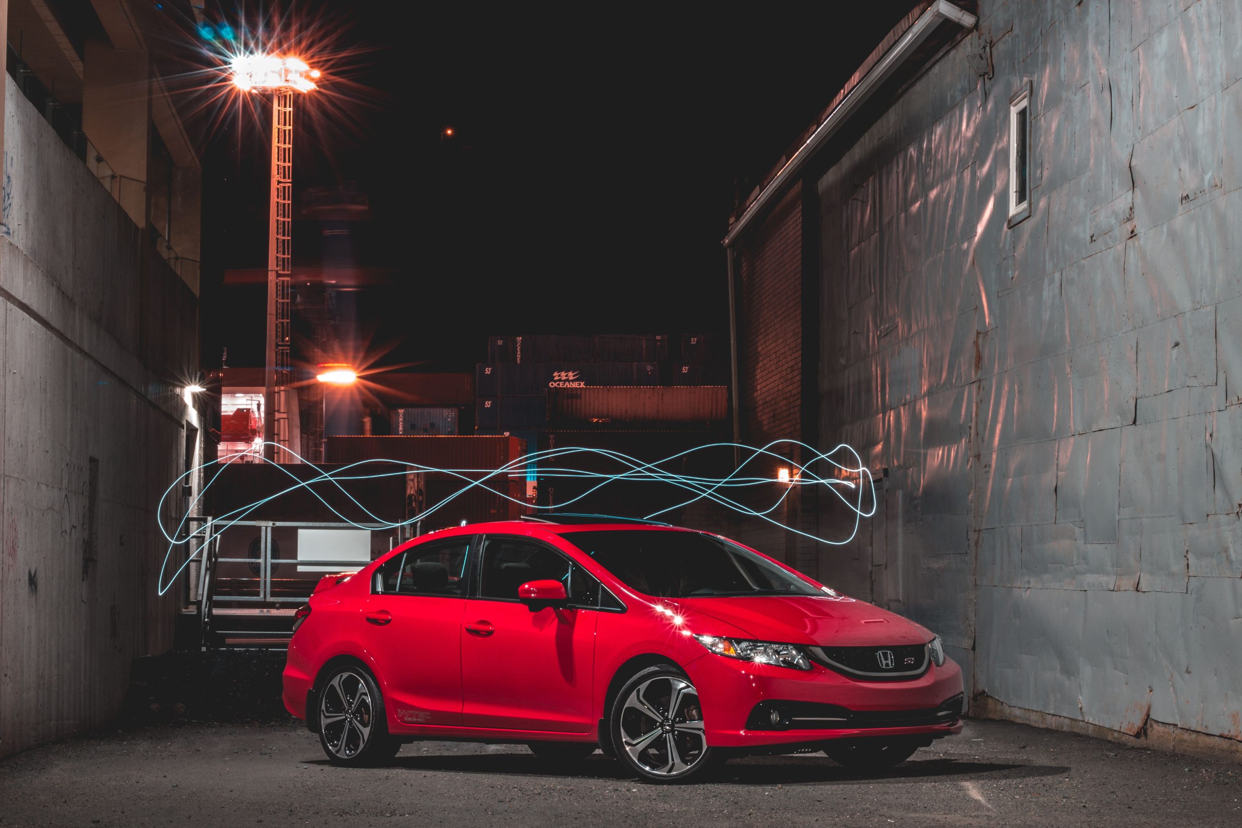Voiture rouge moderne illuminée en zone industrielle