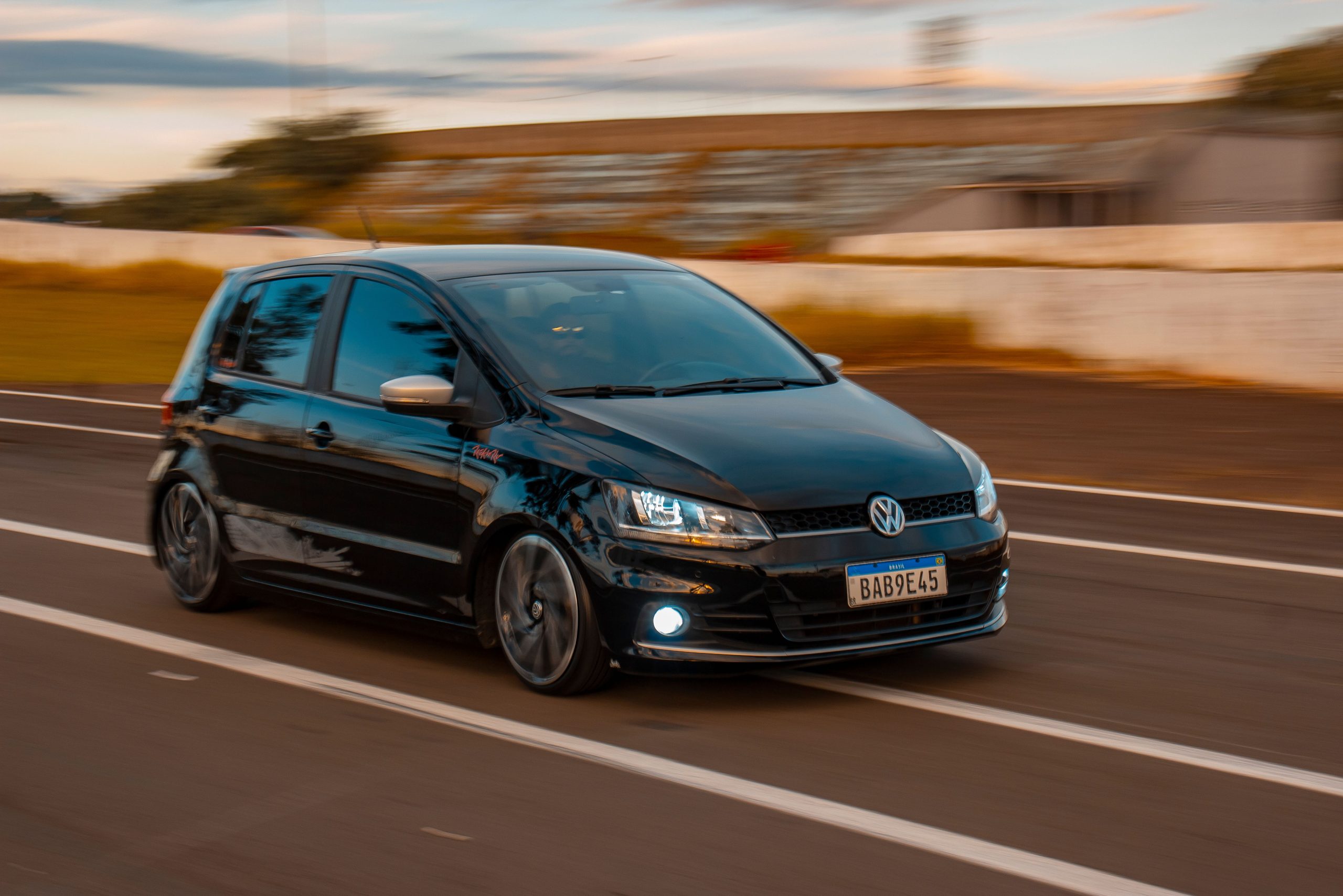 Voiture noire roulant rapidement sur route