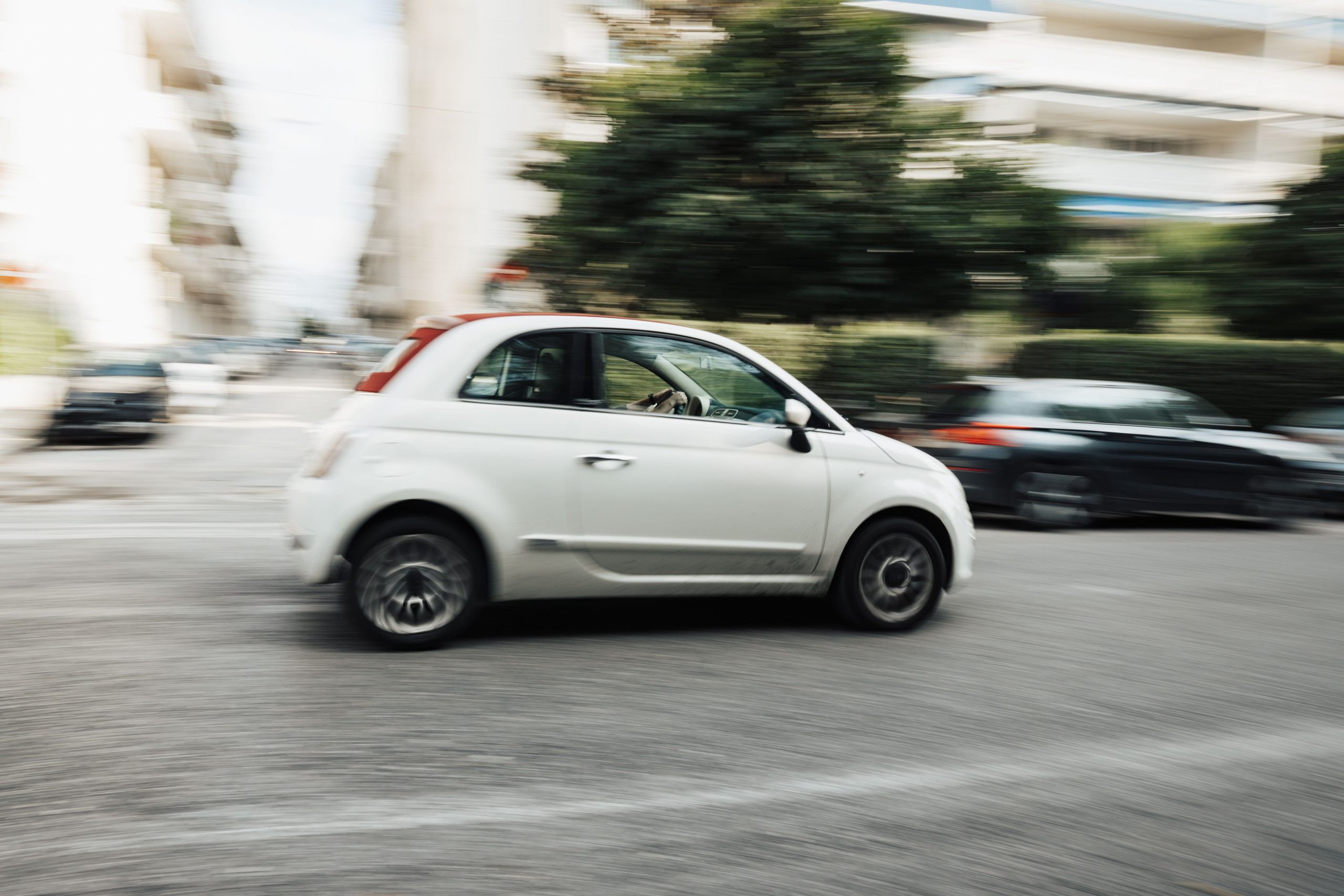 Voiture blanche circulant en milieu urbain mouvement