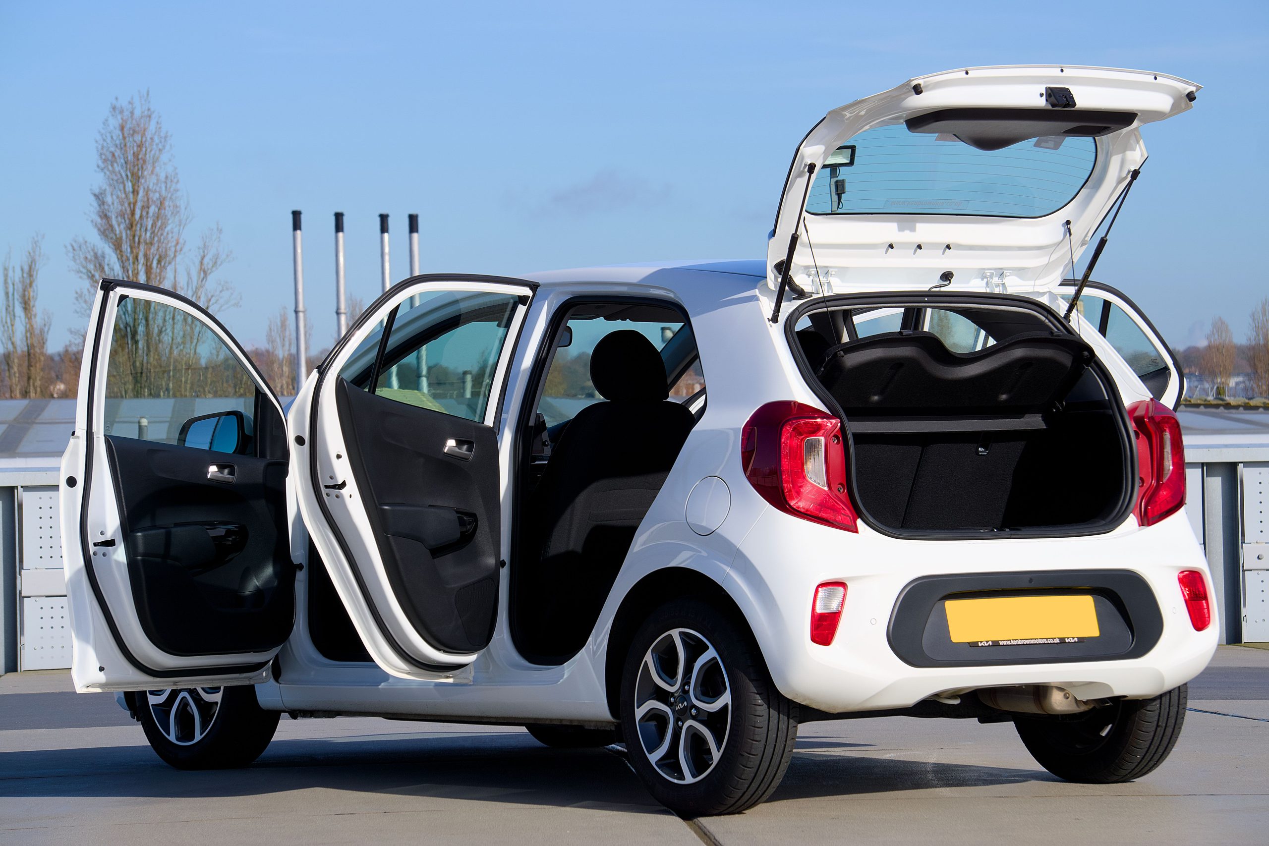 Voiture compacte blanche portes ouvertes en ville