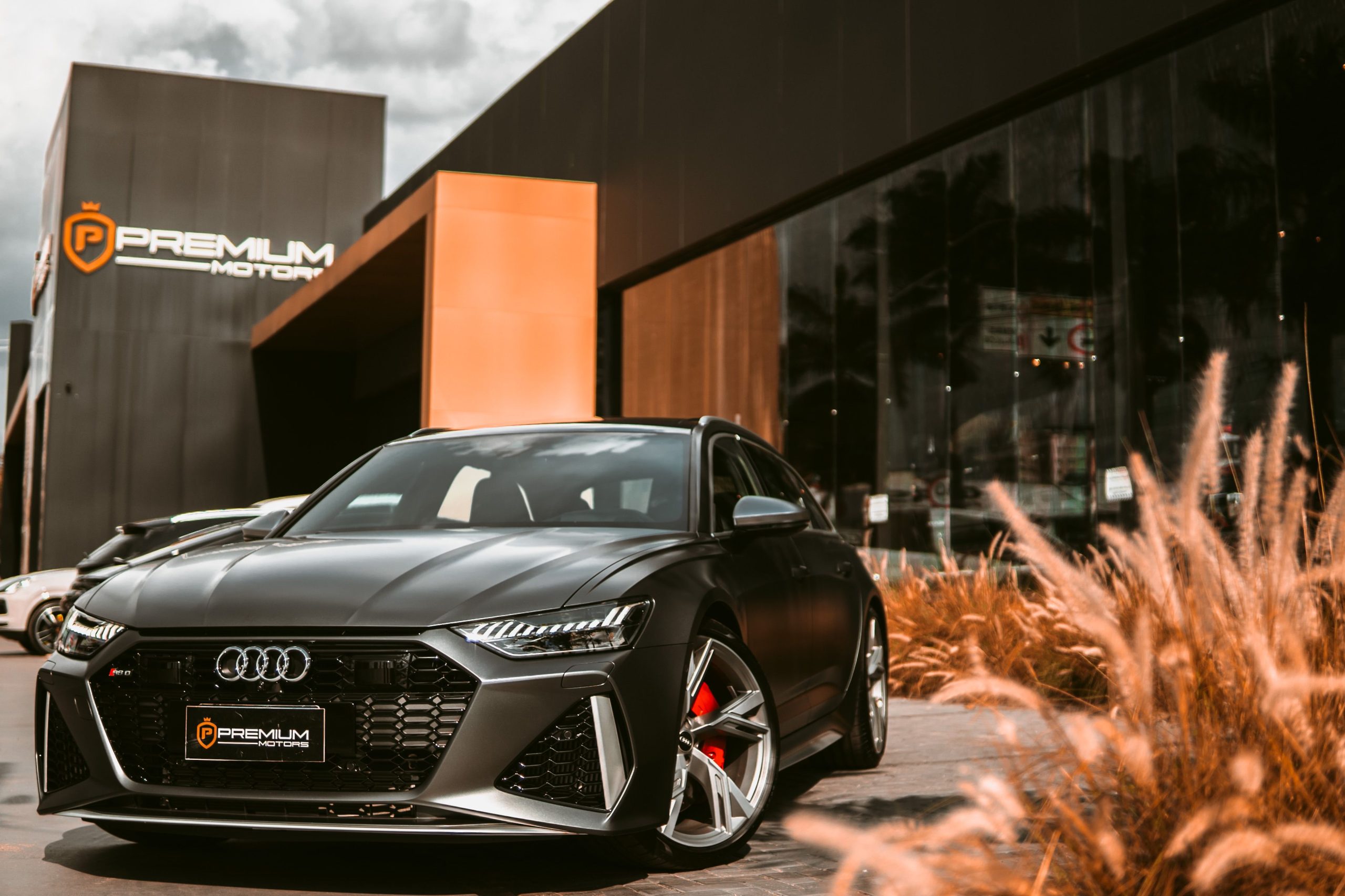 Voiture sportive noire garée devant un showroom
